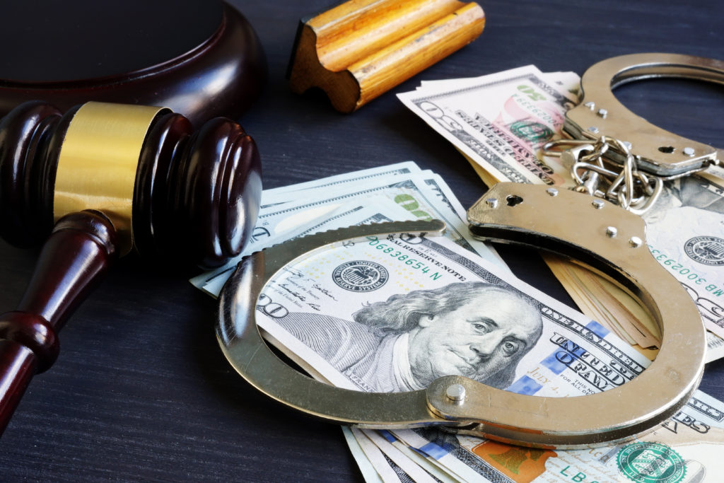 Handcuffs, Money and Gavel on a Table